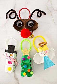 paper plate christmas tree, elf and snowman puppets on a white marble countertop