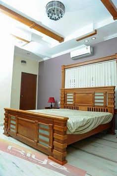 a bed room with a neatly made bed and a chandelier hanging from the ceiling