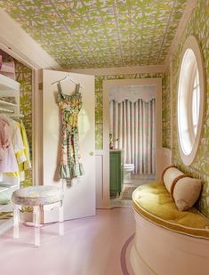 a room with green and yellow wallpaper, pink flooring and white furniture in it