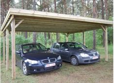 two cars are parked under a carport in the woods