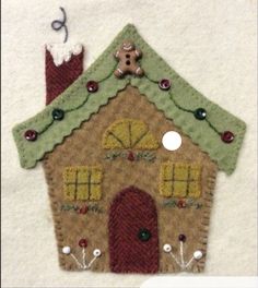 a felt house is decorated with buttons and beads