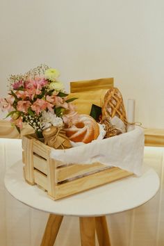 a basket with flowers and bread on a table