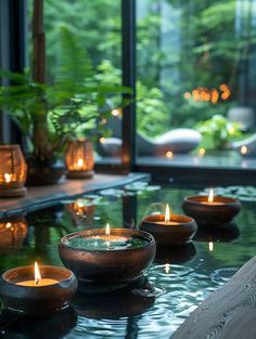 candles are lit on a table in front of a window with large glass panes