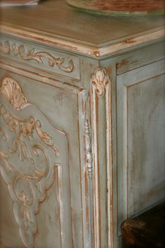 an antique cabinet with carvings on the doors