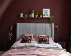 a bedroom with purple walls and white bedding, plants on the wall above it