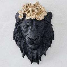 a lion head with flowers on it's head is mounted to the side of a wall