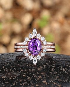 a close up of a ring with a purple stone in the center and diamonds around it