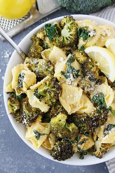 a white bowl filled with pasta and broccoli