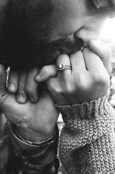 a man is holding his hand to his face while wearing a ring on his finger