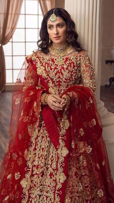 a woman in a red and gold bridal gown