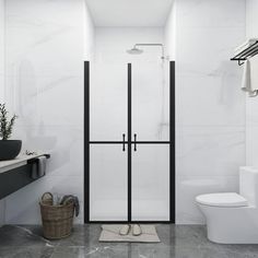 a bathroom with a toilet, sink and shower stall is shown in black and white