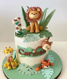 a cake decorated with animals and plants on top of a green platter that says caramel