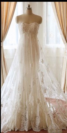 a wedding dress on display in front of a window