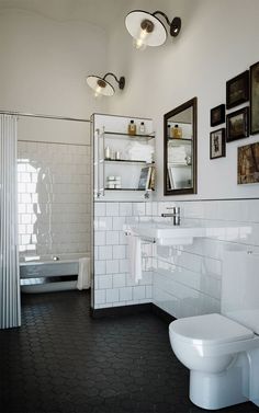 a white bathroom with black and white tile flooring