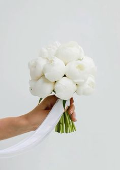 a person holding a bouquet of white flowers