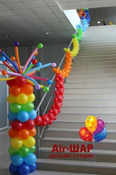 a bunch of balloons that are in the air next to some stairs and railings