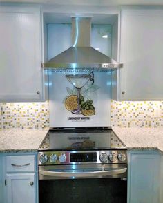 a stove top oven sitting inside of a kitchen next to white cabinets and counter tops