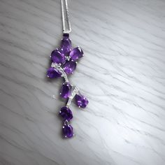 Amethyst Drop Necklace Introducing our natural Amethyst CZ Pendant Necklace, crafted with sterling silver, perfect for those seeking a healing stone pendant. This piece features a drop and oval natural Amethyst gemstone arrangement, including various sizes. The main Amethyst stone weighs 2.20 carats, radiating its captivating purple hue. Set with sparkling cubic zirconia accents in a pristine white color, this necklace exudes elegance. With a metal weight of 6.00 grams, this pendant necklace is Cz Pendant, Purple Hues, Leaf Pendant, Healing Stone, Drop Necklace, Amethyst Stone, Amethyst Gemstone, Healing Stones, Stone Pendants