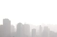 the city skyline is smoggy with tall buildings