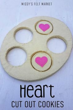 a heart cut out cookie with pink hearts on it