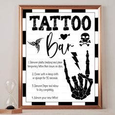 a black and white poster with the words tattoo bar written on it, in front of a wooden frame