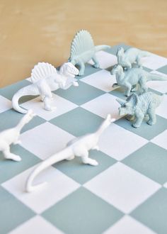 small plastic dinosaurs on a checkered board