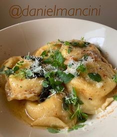 a white bowl filled with pasta covered in sauce and parmesan cheese