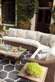 an outdoor living room with wicker furniture