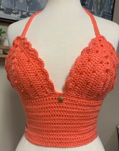 a mannequin wearing an orange top with crochet