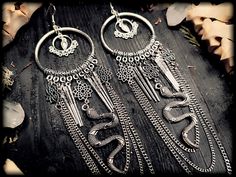 Save the Etsy fees and order from my own shop! www.deathwitch.de Beautifully long and uniquely crafted snake earrings with spikes & chains. The earrings are a bit heavier and all the chains make for a nice jingle on the ear ;)) You can also have them upgraded with 925 sterling silver hooks! I'll be happy to package your order as a gift! Please select gift packaging during the ordering process ;)) Color: Antique Silver / Gunmetal Material: metal Size approx: 18 x 5 cm Gothic Dangle Body Jewelry In Metal, Gothic Metal Dangle Body Jewelry, Edgy Metal Festival Earrings, Gothic Dangle Earrings For Festival, Witchy Dangle Earrings For Festival, Handmade Gothic Earrings For Festival, Gothic Nickel-free Earrings For Alternative Fashion, Gothic Metal Earrings For Alternative Fashion, Gothic Nickel-free Jewelry For Festivals