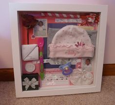 a baby's gift set in a shadow box