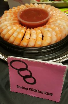 shrimp cocktail ring served on a platter with pink paper for price label and sign