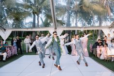 two men in suits and ties dancing on a dance floor with other people behind them