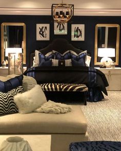 a bed room with a neatly made bed and two mirrors on the wall above it