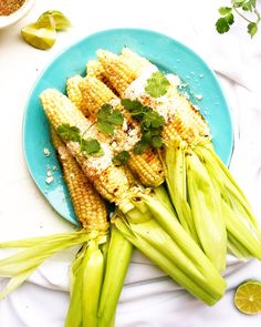 grilled corn on the cob with lime and parmesan cheese, garnished with cilantro