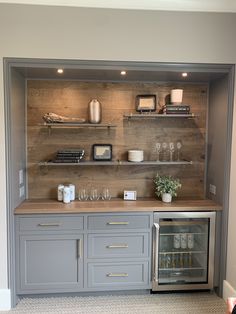 a kitchen with gray cabinets and shelves filled with wine glasses