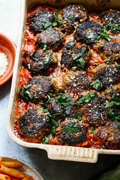 a casserole dish with meatballs and vegetables in it next to other dishes