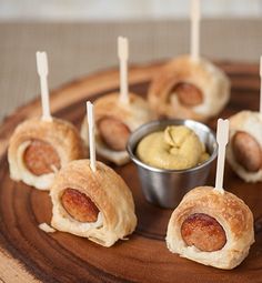 small appetizers with toothpicks and dipping sauce on a wooden platter