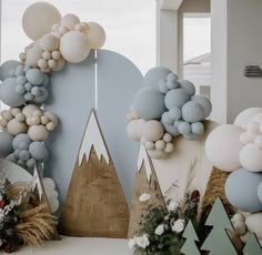 balloons and trees are on display in front of a backdrop that looks like mountain tops