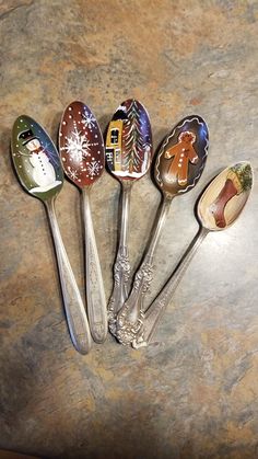 five spoons with different designs on them sitting on a counter top next to each other