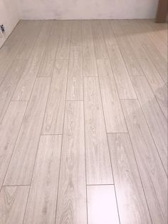 a bathroom with white walls and wood flooring