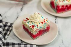 a slice of cake with white frosting and sprinkles on a plate