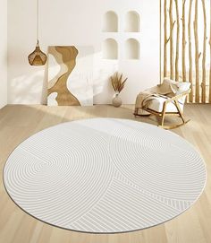 a living room with white walls and wooden floors is pictured in this image, there is a circular rug on the floor