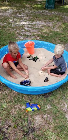 two young boys playing in a sand pit