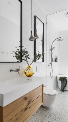 a modern bathroom with white walls and wood accents