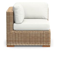 a wicker chair with white cushions and pillows on the armrests, against a white background