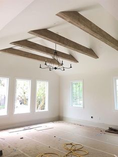 an empty room with three windows and some beams in the ceiling that have been installed