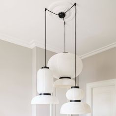 three white lamps hanging from the ceiling in a room