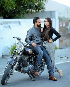 a man and woman are sitting on a motorcycle