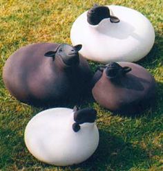 three black and white pots sitting on top of green grass